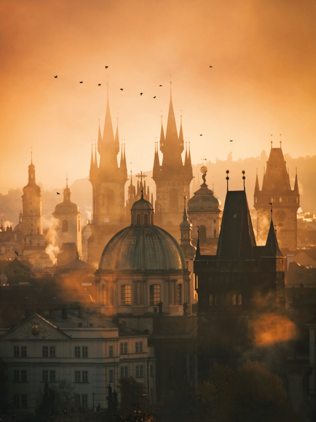 Prague spires glowing in golden morning backlight